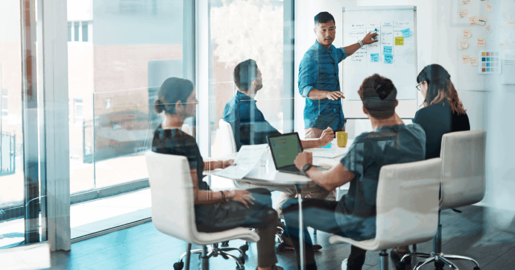 Equipe reunida em uma sala de reunião discutindo estratégias para estruturar a área comercial da empresa